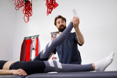 Professional physiotherapist diagnosing a lumbar herniated disc. Young woman at a doctor's appointment with a rehabilitologist