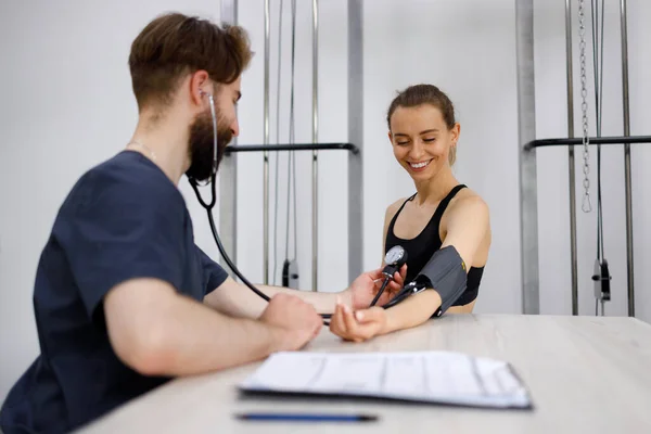 Happy fitness woman on physical examination at sports doctor.