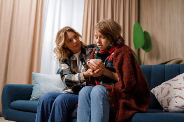 Annem ateşli hasta kızıma sıcak çay veriyor.