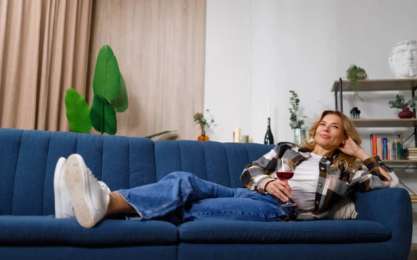 Kanepede Uzanmış Televizyon Izlerken Şarap Içen Bir Kadın — Stok fotoğraf