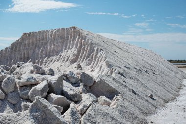 Dağlara özenli bir şekilde odaklanmış bulutlu mavi gökyüzüne karşı doğal tuz çıkarılmış. Ukrayna 'da taş tuzu endüstriyel çıkarımı.