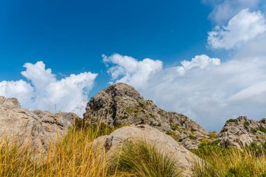 Dağları ve mavi gökyüzü olan güzel bir manzara.