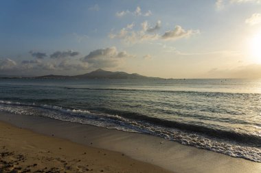 Okyanusun arka planında kum ve deniz dalgaları olan güzel bir sahil.