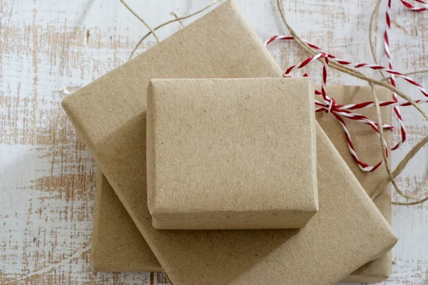 Geri dönüşümlü kağıt şerit yay ile sarılmış hediye kutusu — Stok fotoğraf