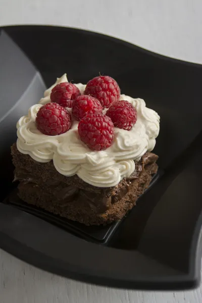 Chocolate cake with cream and raspberries — Stock Photo, Image