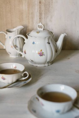 Kahvaltı çayı, porselen porselenlerle servis edilir, güllerle, kırsal bir ortamda..