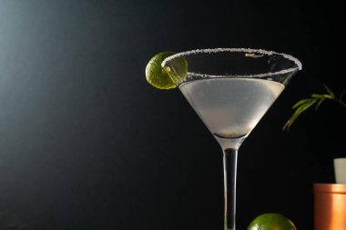 Tuzlu çerçeveli limonlu limonlu otantik margarita kokteyli, toprak renkli yüzey ve zarif koyu arkaplan, tekila, limon, acı portakal likörü ile süslenmiş lezzetli Meksika içeceği.