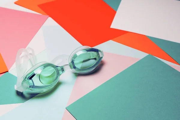 Tyrkysové Plavecké Brýle Gumovým Popruhem Vícebarevném Geometrickém Pozadí Nikdo Produktová — Stock fotografie