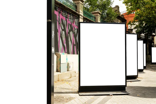 Outdoor mockup of a blank information posters on the sidewalk, empty vertical street banners templates ; billboard placeholder mock-up on a city boulevard in an alleyway outdoors