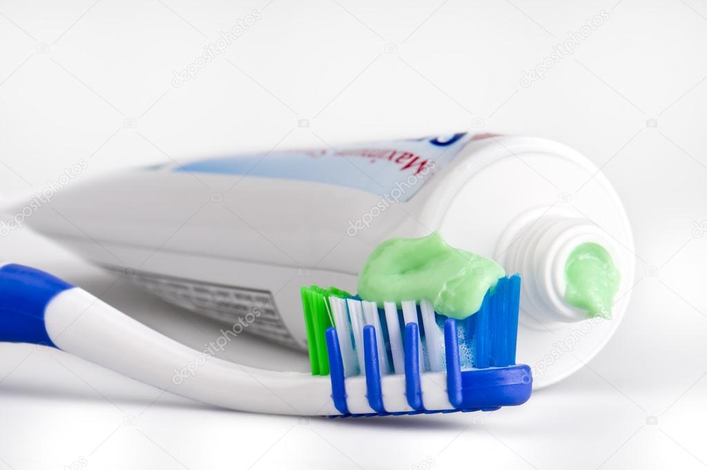 Closeup of a toothbrush with dental paste and tube. Macro shot with use of selective focus. All logos removed.
