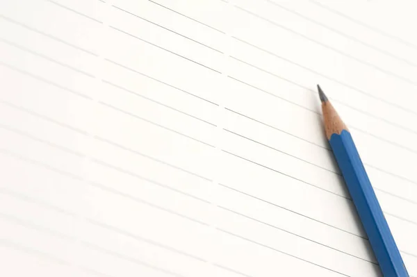 Sharp blue pencil on lined paper with space to place your message or text between the lines