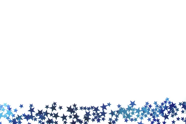 Blue star festive border with a myriad of small stars scattered along the bottom of the frame isolated on white with copy space