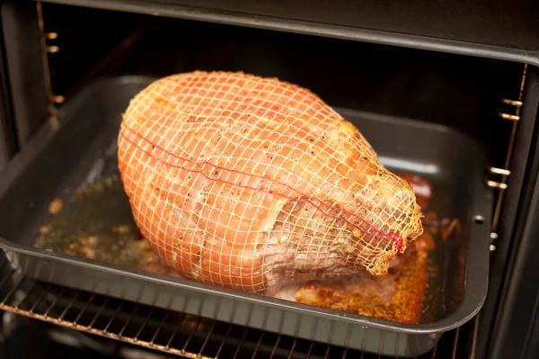 Roasting a succulent cut of pork with crackling in the oven in a net on a metal grill pan or oven dish