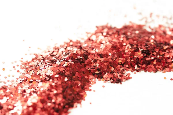 Trail of Red Glitter Across White Studio Surface - Abstract Background of Sparkling Red Glitter