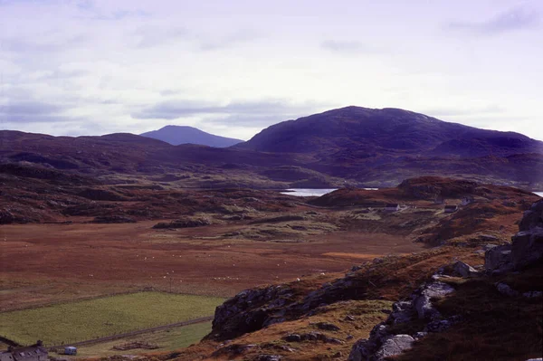 Mystical Hebrides landscape with purple mountains overlooking lowlands and a pretty lilac tinge to the sky