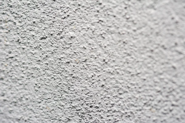 Rendered white wall background texture with a rough stippled surface to the plaster, full frame with center focus
