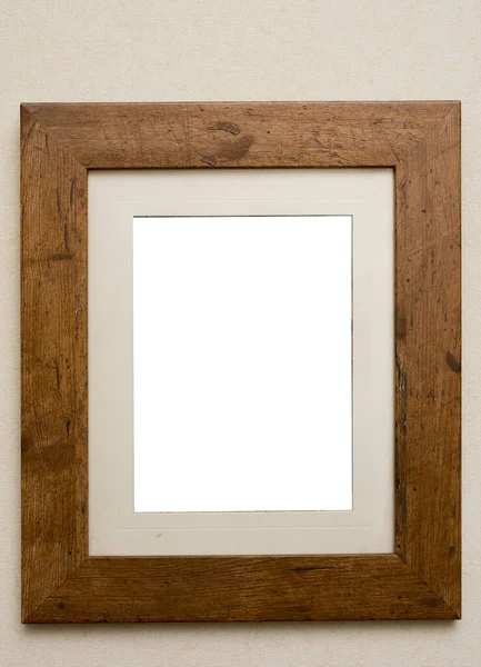 Empty plain rustic wooden picture frame with a beige colored interior mount board and copy space on a neutral beige background