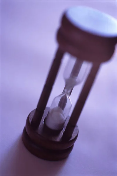 Hour glass or egg timer with sand running through the glass bulbs marking the passage of time and the countdown to the end or deadline