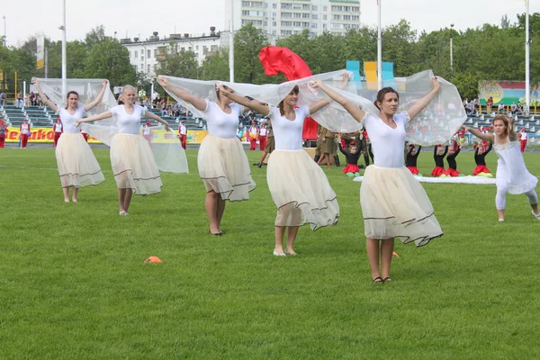 Group of women in white dresses on a green field of stadium — Stock Photo, Image