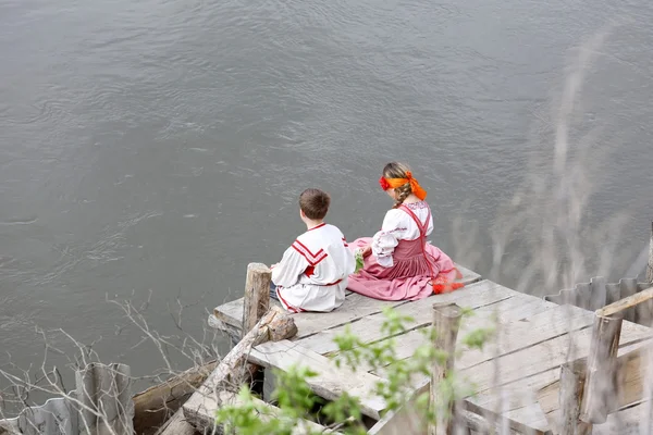 Adolescentes em vestidos nacionais na margem do rio — Fotografia de Stock