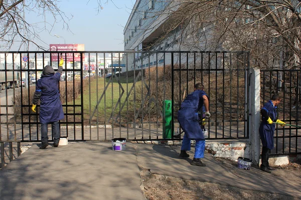 Trabalhadores convidados pintam uma cerca — Fotografia de Stock