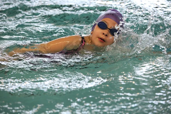 Das Mädchen, das im Pool im Kriechstil schwimmt — Stockfoto