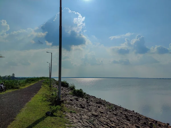 班尼索萨坝旁边的沥青清澈空旷的照片 安装在附近公路上的太阳能电线杆 蓝天白云映衬 在日光下拍摄的照片 — 图库照片