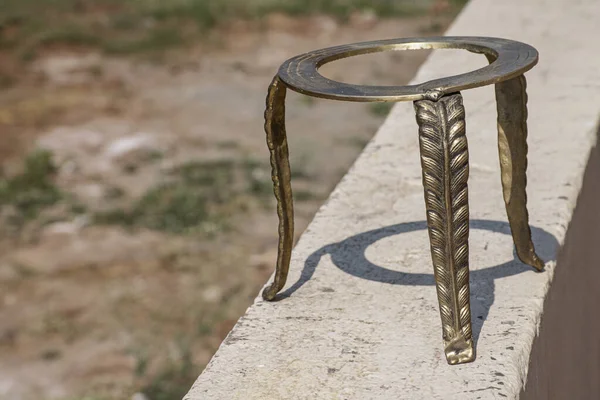 Eski usul el yapımı pirinç yüzük standı ya da parlak güneş ışığı altında duvarda duran tabure. Fotoğraf Kolhapur, Maharashtra, Hindistan 'da çekildi..