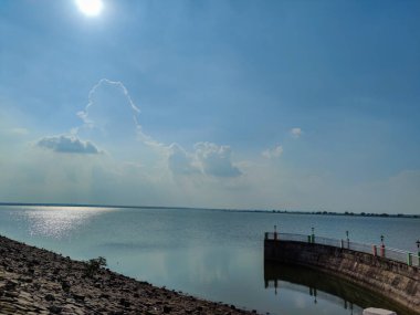 Stock photo of U shape walk board leading to Bennithora dam,solar electric lamp installed at walk board. Blue sky with dam water on background, Picture captured under bright sunlight at Bennithora dam