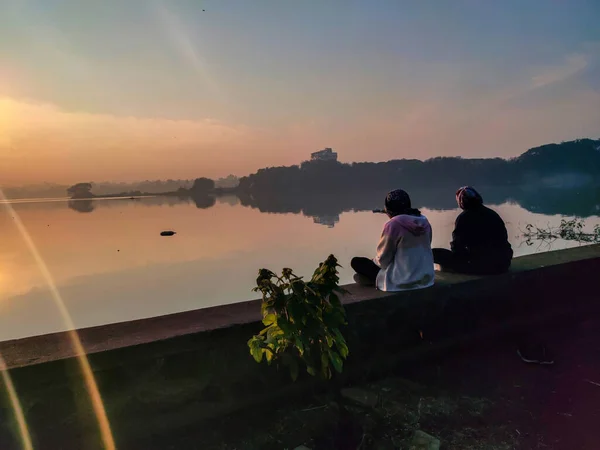 印度科拉普尔 2020年12月5日 照片摄于印度科拉普尔的兰卡拉湖 照片中两个年轻的印度女孩坐在湖边 在冬季享受美丽的日出 — 图库照片