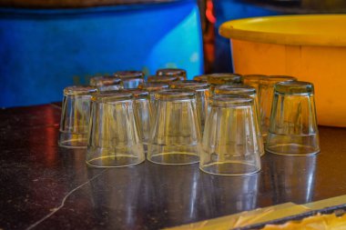 Yıkanmış cam çay fincanlarının resmi otelin arka planındaki siyah granit mutfak tezgahında duruyordu. Fotoğraf Gulbarga, Karnataka, Hindistan 'da çekildi..