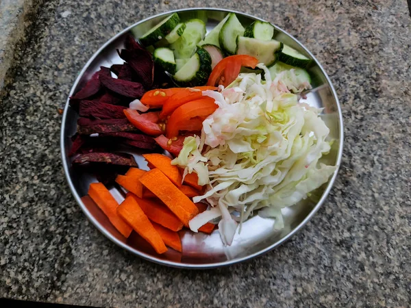 Domates, pancar, lahana, salatalık ve havuçlu klasik sağlıklı ve renkli salata tabağı. Doğa ışığı altında masalardan uzak tutulur. Fotoğraf Bangalore, Karnataka, Hindistan 'da çekildi..