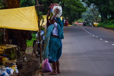 Kolhapur, İndiana - 15 Eylül 2019; 50-60 yaş arası Hintli kadınlar haftalık köy pazarında sari giyerek market alışverişi yaparken ve Kolhapur 'da kafasında çanta taşırken çekilmiş.