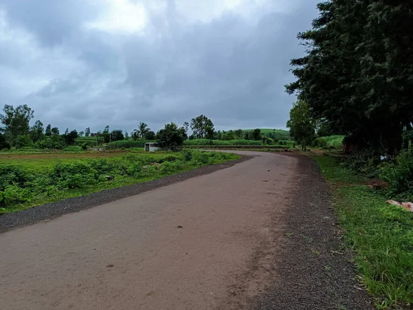 风景秀丽的沥青路面连接着农村地区 道路两旁的农田 背景多云的天气 在印度马哈拉施特拉邦Kolhapur市拍摄的照片 — 图库照片