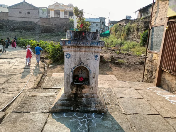 Khidrapur, İndiana - 6 Kasım 2021; Hindu tapınağının önünde bulunan beyaz boyalı taş, katte ya da çömlek boyalı eski kutsal fesleğen bitkisinin stok fotoğrafı.