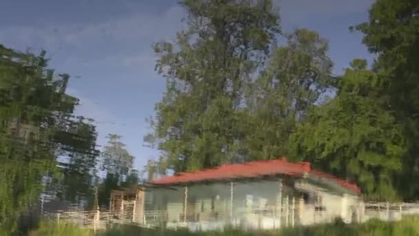 Отражения деревьев и домов в озере — стоковое видео