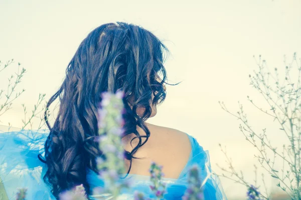 kır çiçekleri bir ortamda kız oturuyor