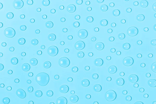 Water drops on a pastel blue background. Water texture close up. Backdrop glass covered with drops of water. Water bubbles. — Stock Photo, Image