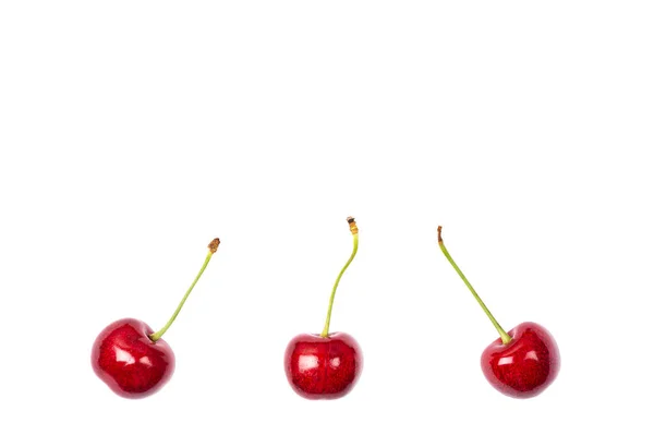 Cereza roja madura aislada sobre fondo blanco. Fotografía macro de cerca. Tres cerezas sobre fondo blanco. Banner con espacio de copia —  Fotos de Stock