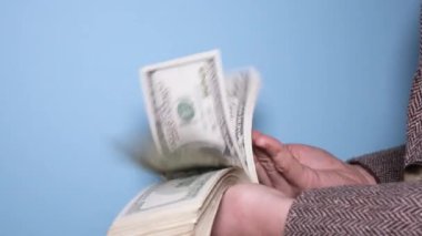 Eller para sayıyor ve paralarla oynuyor. Bir insan büyük bir tomardan dolar sayar. 4K çözünürlük videosu.