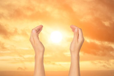 Gün batımının arka planında güneşi tutan açık palmiyeler. Seyahat ve ilham, meditasyon konsepti