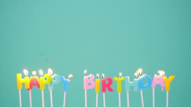 Happy Birthday concept Made of Burning Colorful Candles on blue or turquoise background. Slow motion full HD video. Wish a happy birthday idea. — Stock Video