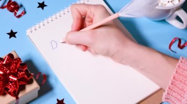 Kız ya da kadın Noel Baba 'ya mektup yazıyor. Yeni yıl ya da Noel tatili konsepti videosu. 4K çözünürlüğü