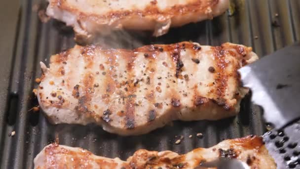 Ovanifrån på Kött är stekt på en elgrill på nära håll. 4K upplösning video. Fläskstek på nära håll stekt och rökt på grillen. — Stockvideo