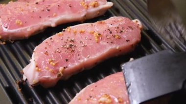 Biftekler ızgarada pişiyor. 4K çözünürlük videosu Et elektrikli ızgarada kızartılır. Yakın plan.