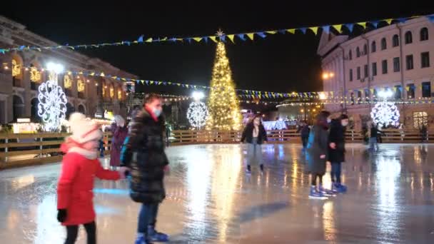 Люди катаются на коньках, украшенных новогодними и рождественскими праздниками. Видео с разрешением 4K — стоковое видео