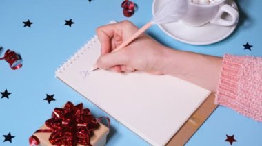 Kız ya da kadın Noel Baba 'ya mektup yazıyor. Yeni yıl ya da Noel tatili konsepti videosu. 4K çözünürlüğü