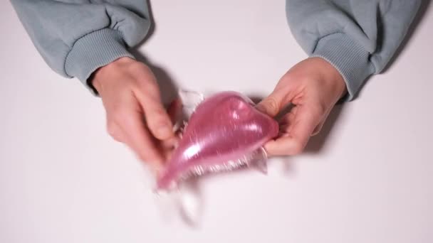 Рука грати з стиснути рожеву рибу Рука зап'ястя Вправа Іграшка-антистрес. Іграшка для полегшення стресу ізольована на білому тлі. Відео роздільної здатності 4k — стокове відео