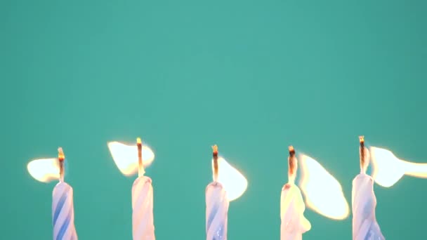 Happy Birthday concept Φτιαγμένο από Burning Colorful Candles σε μπλε ή τυρκουάζ φόντο. Σβήνω κεριά γενεθλίων πέντε χρόνων. Αργή κίνηση βίντεο full HD — Αρχείο Βίντεο