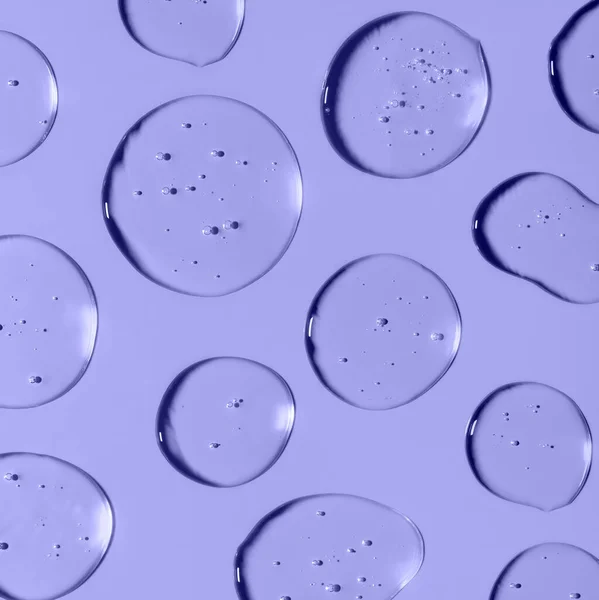 Transparent Gel σταγόνες που σχηματίζουν φόντο ή μοτίβο. Gel σταγόνες σε ανοιχτό μωβ φόντο. Έννοια για καλλυντικά προστασίας ιών. Τετράγωνη σύνθεση Trendy banner με 2022 χρώμα του έτους πολύ peri — Φωτογραφία Αρχείου